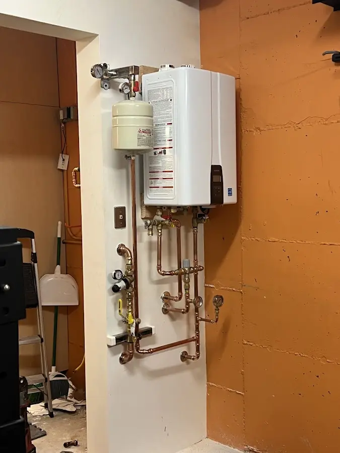 Plumbing technician inspecting water heater connections in Waukee